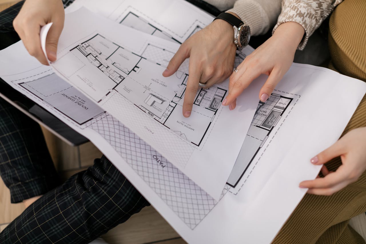 gallery-6 Two people examining architectural blueprints, focusing on project details.